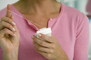 Close-up of a mid adult woman holding dental floss